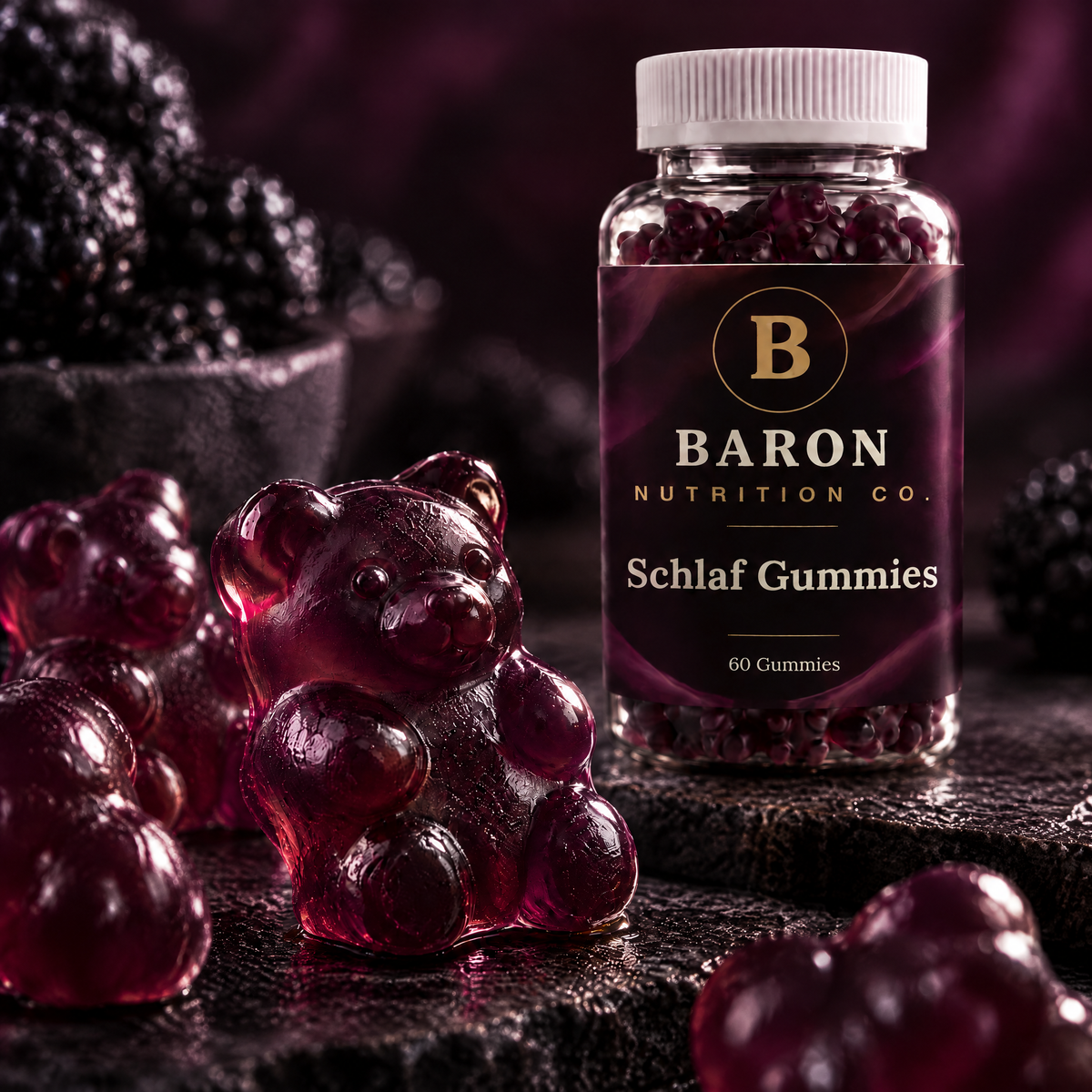 Close-up of a dark berry Baron sleep gummy bear beside the jar, with blackberries in the background